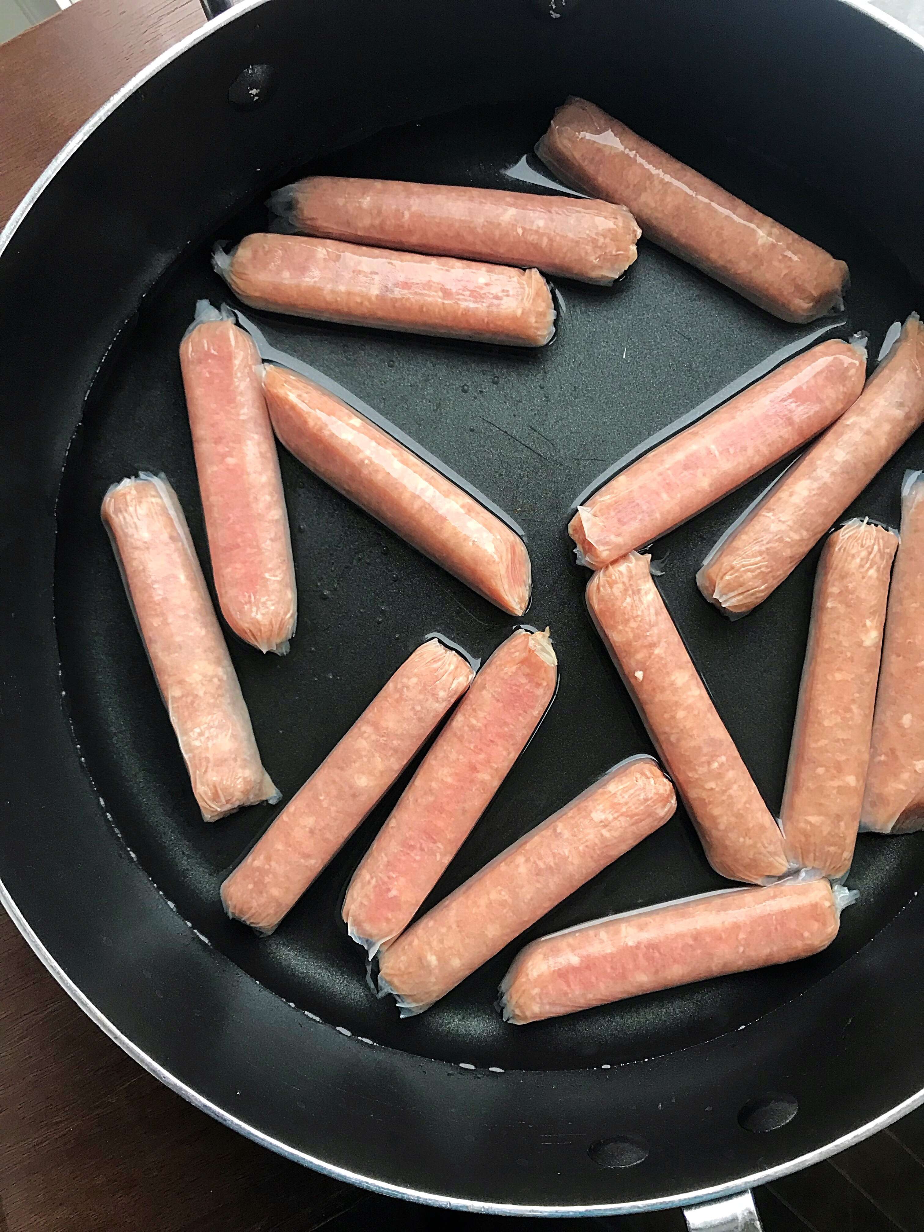 Sausages in a large skillet with water